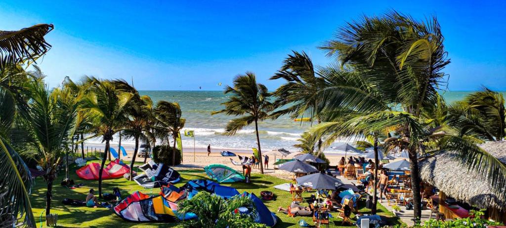 a beach with people and palm trees and the ocean at Casa Janjão in Icaraí
