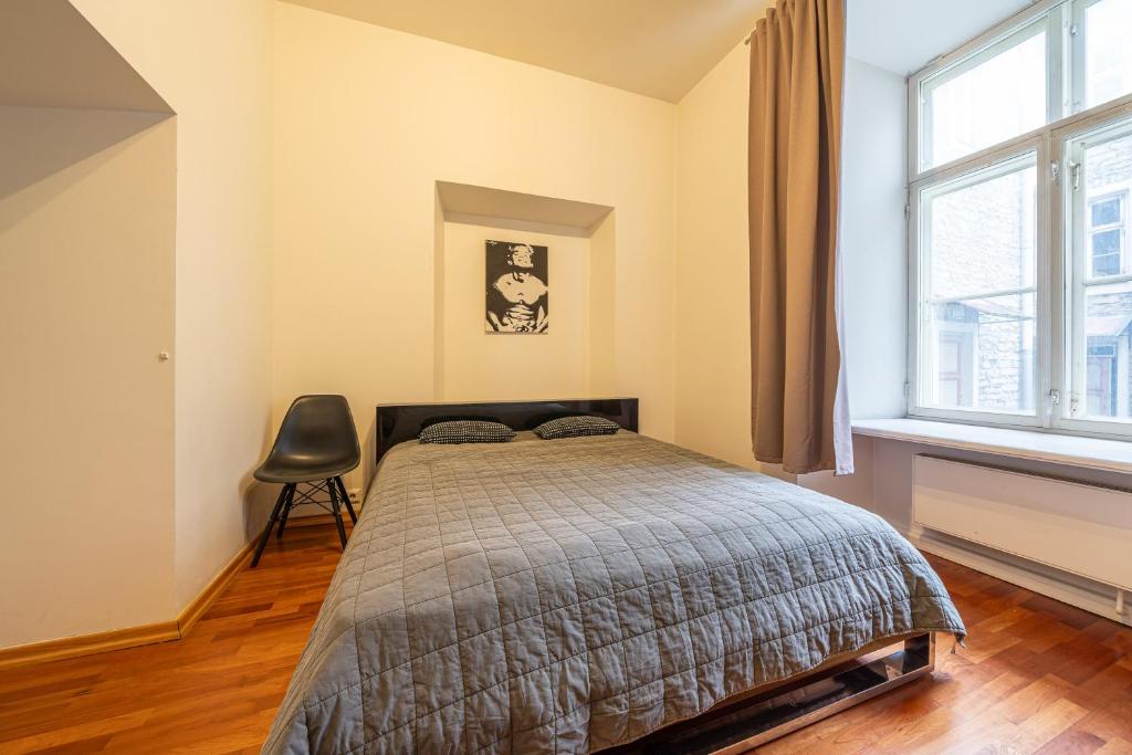 a bedroom with a bed and a chair in it at Old Town - Best Location Apartment in Tallinn