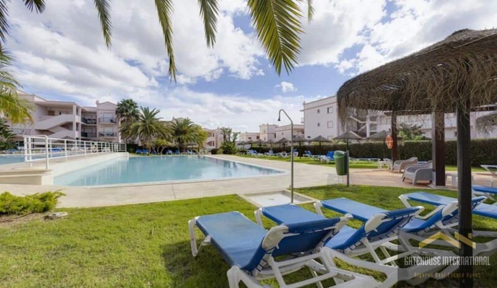 a swimming pool with lounge chairs and a resort at Beachside oasis with Pool in Luz