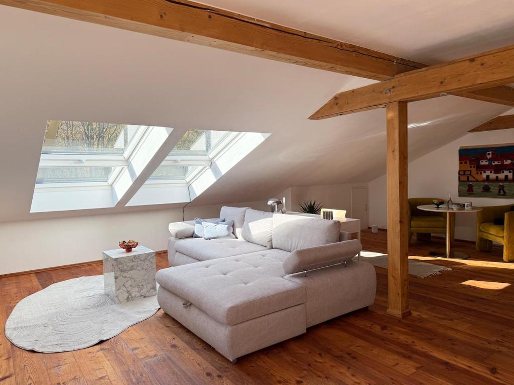 a living room with a white couch and a table at Soleils Living I See & Berge I Starnberger See in Berg am Starnberger See