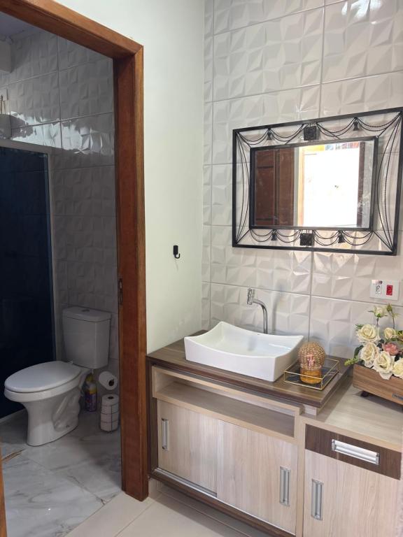 un bagno con lavandino, WC e specchio di Rancho do Viajante Flat APARTAMENTO A a Castro