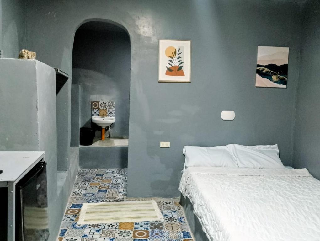 une petite chambre avec un lit et un lavabo dans l'établissement D Sanctum Resort, à General Santos