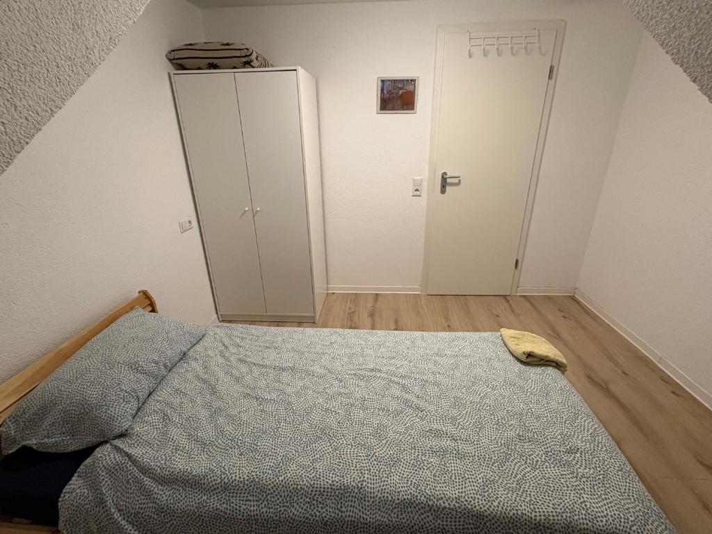 un dormitorio con una cama y un armario en Cozy Room close to station, en Stuttgart