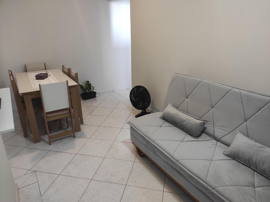 a living room with a couch and a table at Apartamento com suíte no bairro de Santa Monica in Uberlândia