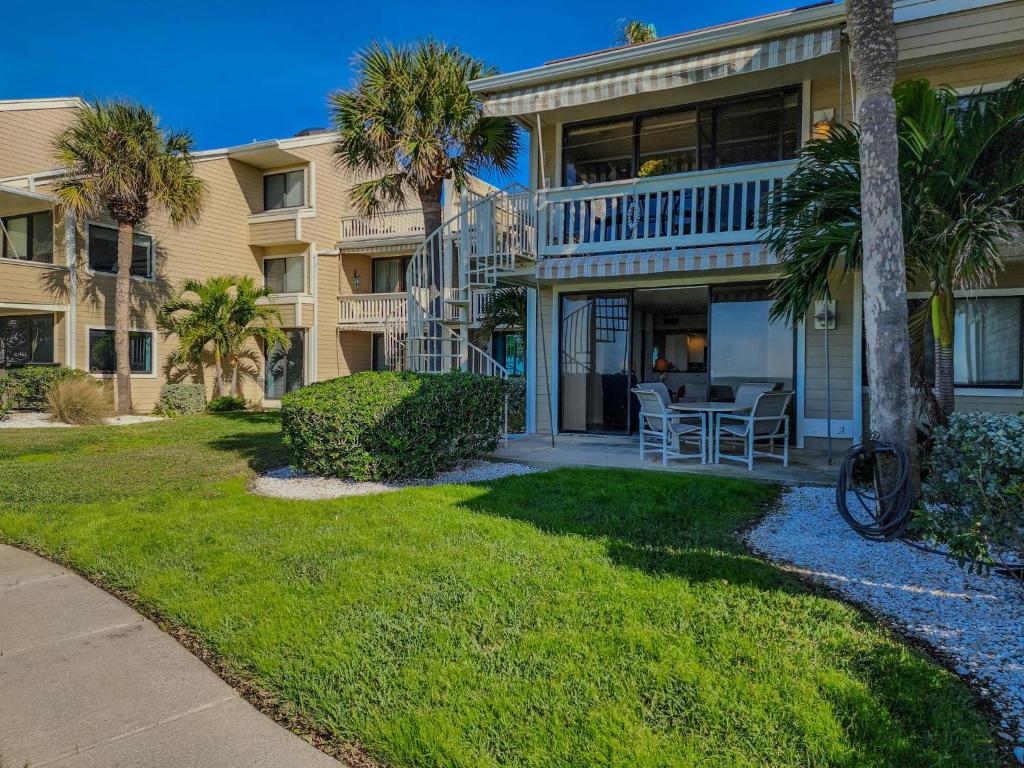 een huis met palmbomen en een tafel in de tuin bij Sonrisa 11 in Clearwater Beach