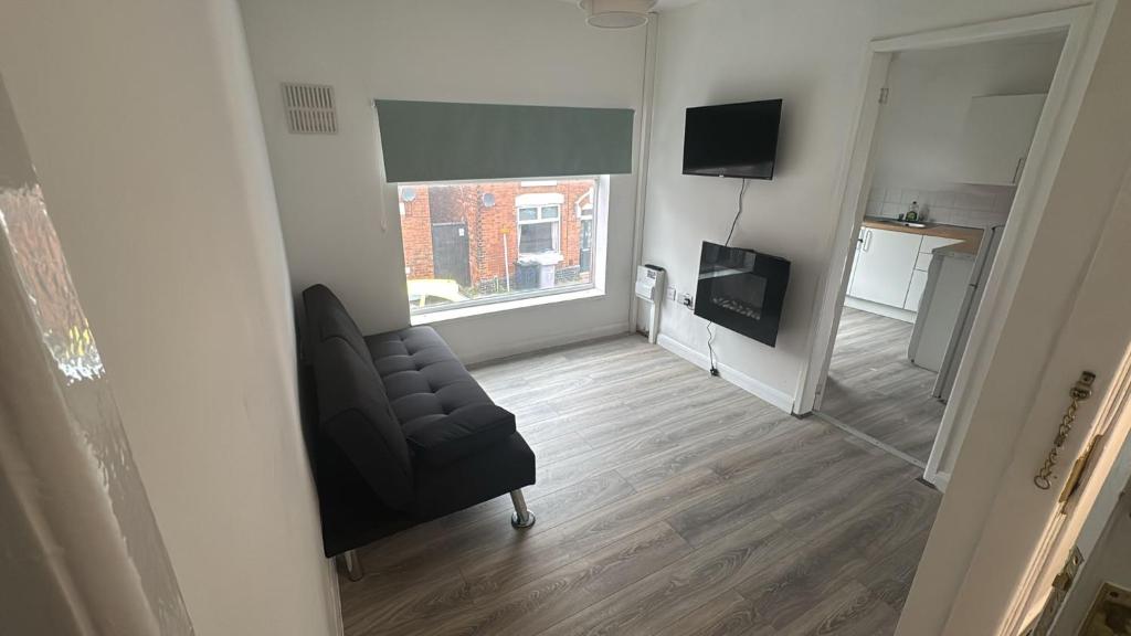 a living room with a chair and a window at Stadium Apart - Free Parking & WiFi in Crewe