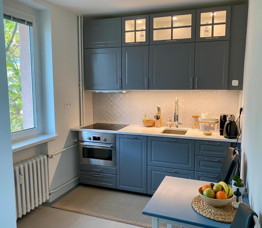 - une cuisine avec des armoires bleues et un bol de fruits sur une table dans l'établissement CASTE Apartment, 1-4 guests, Garage, Historical Downtown, à Vinohrady