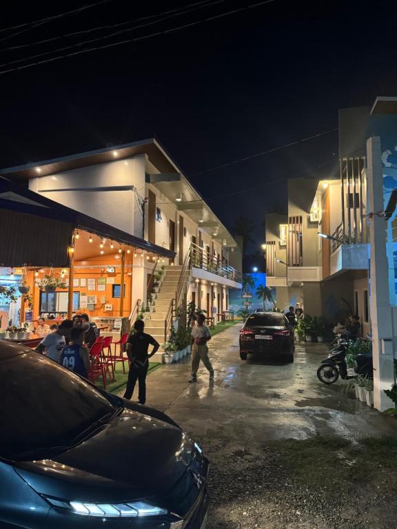 Un groupe de personnes marchant dans une rue la nuit dans l'établissement BALAI MALINAWON Hotel 3, à General Luna