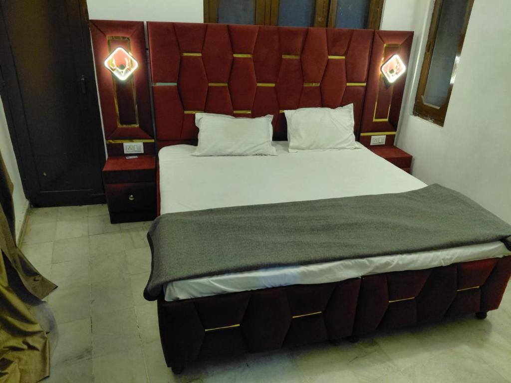 Un dormitorio con una cama grande con cabecero rojo. en Hotel Gurujee residence, en Amritsar