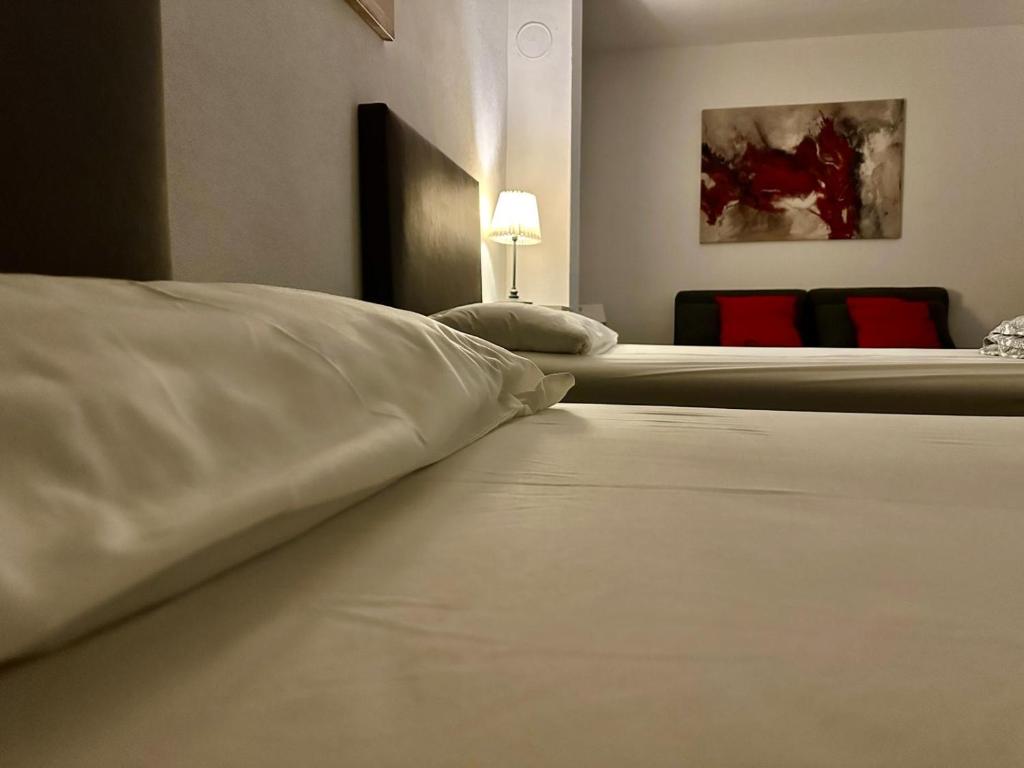 two beds in a hotel room with white sheets at Fiddelhof in Bad Hersfeld