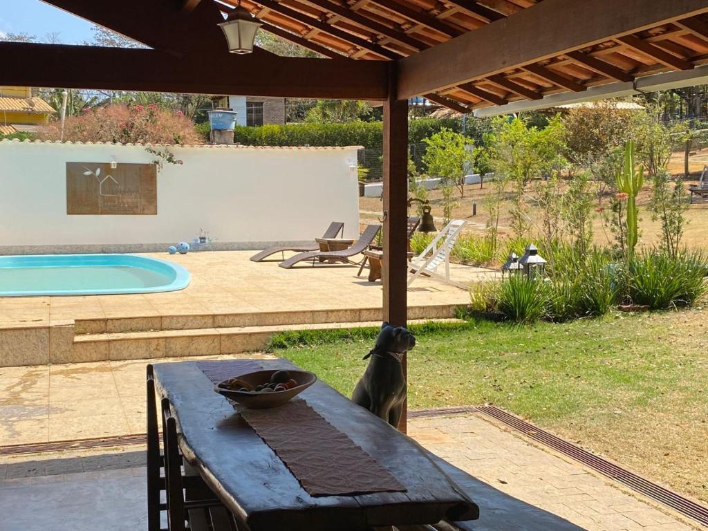 a table with a bowl on it next to a pool at Bangalô Charme Serra do Cipó in Santana do Riacho