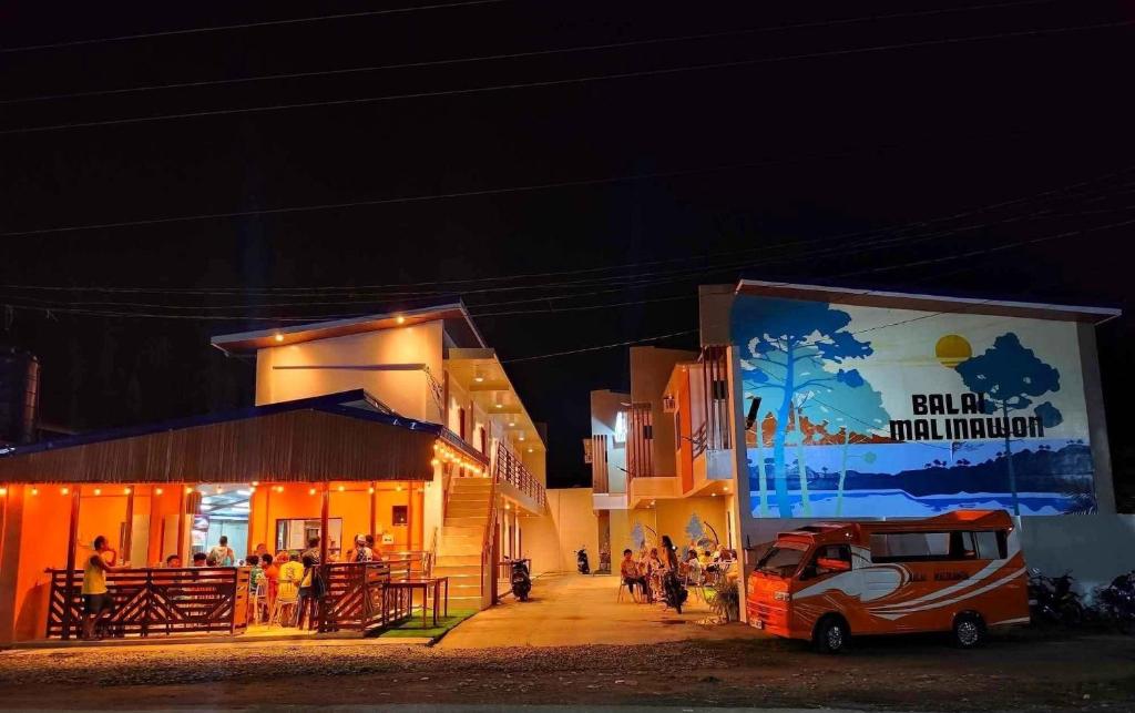 un groupe de personnes debout à l'extérieur d'un bâtiment la nuit dans l'établissement BALAI MALINAWON - Villa 1, à General Luna