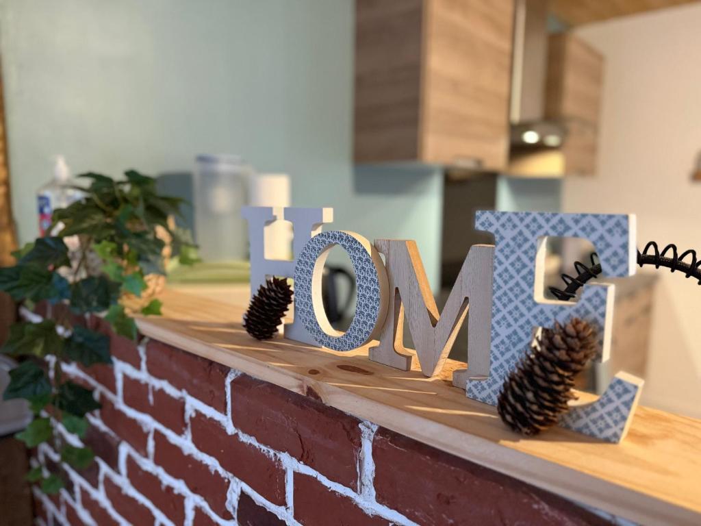 a sign that says love on top of a brick wall at Appartement 6/8 personnes in Petite Chaux