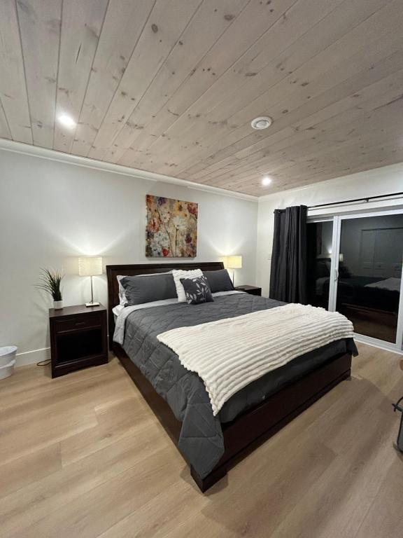 een slaapkamer met een groot bed en een raam bij Garagemahal on Glengyle in Milton Station