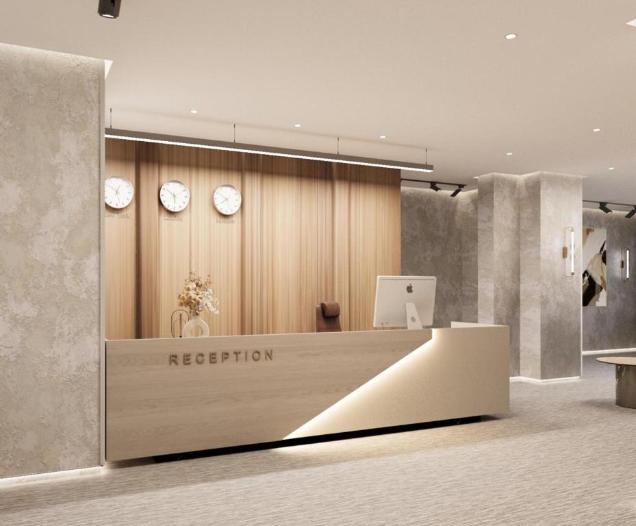 a reception desk with clocks on the wall at Cloud Deluxe Hotel in Mekhrably