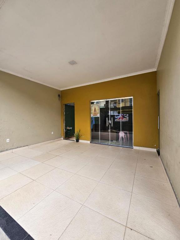 um quarto vazio com paredes amarelas e piso em azulejo em Grande metropóle de Belém em Ananindeua