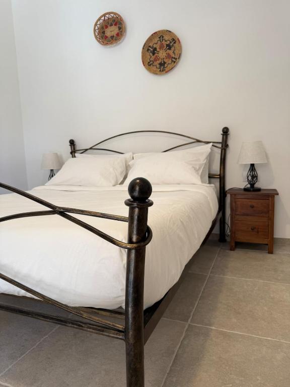 a bedroom with a large bed with white sheets and pillows at La Villeta di Nonna in Selargius