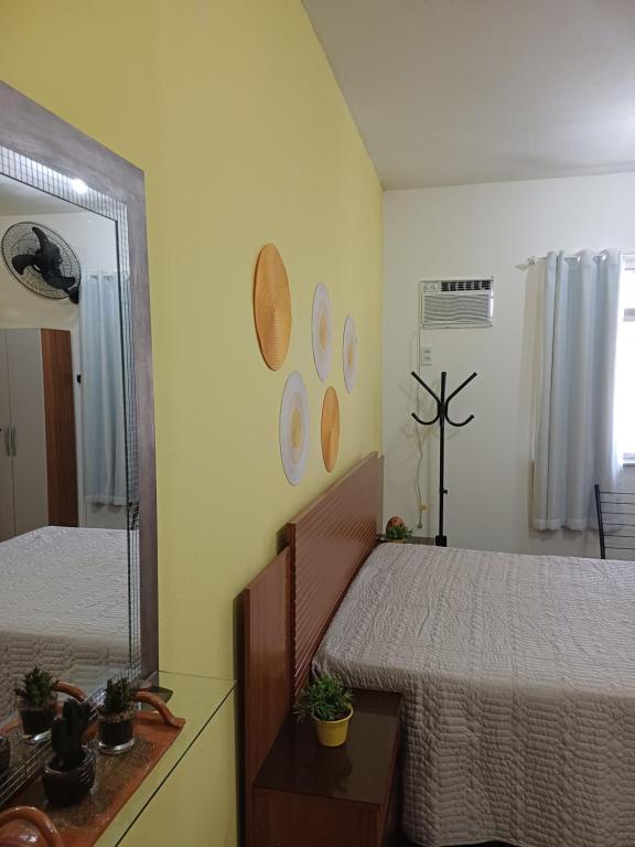 a bedroom with two beds and a mirror at Kitnet estrela in Campos dos Goytacazes