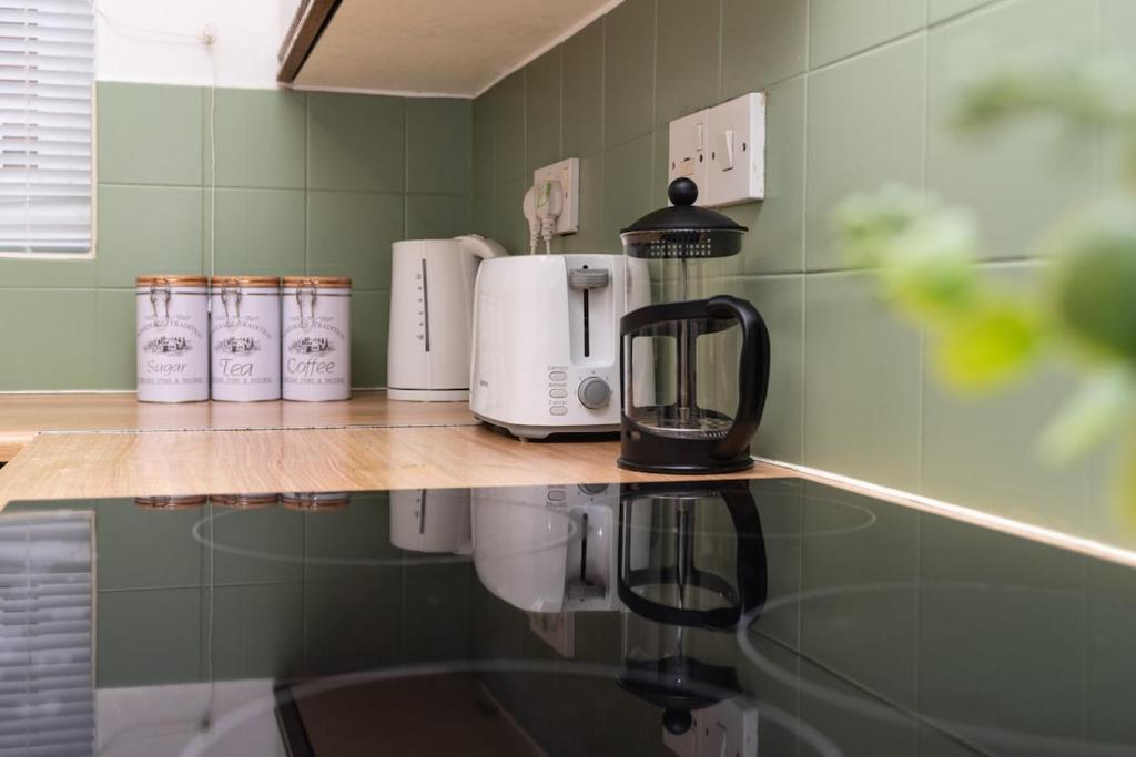 a counter with a coffee maker and affeepot at Wellington Modern Studio - Free Parking in Wellington