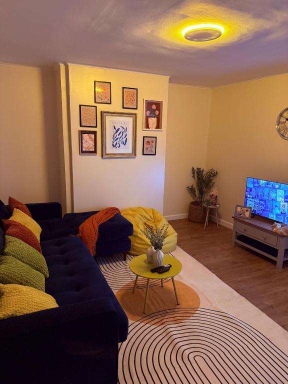 a living room with a blue couch and a tv at Grand Haven Dudley in Dudley