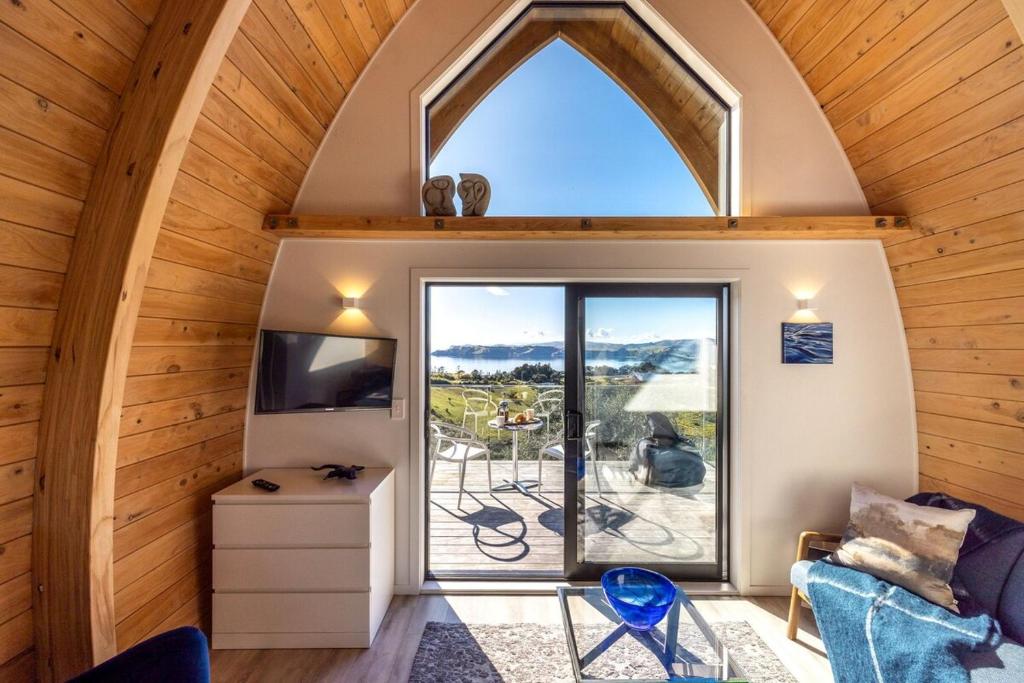 an attic room with a large window and a view of a patio at Perch on the Ridge by Waiheke Pure in Waiheke Island