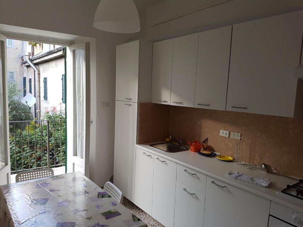 a kitchen with white cabinets and a table and a window at Appartamento Federica in Senigallia