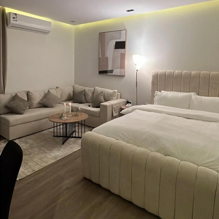 een slaapkamer met een groot bed en een woonkamer bij نور هوستيل in Riyad