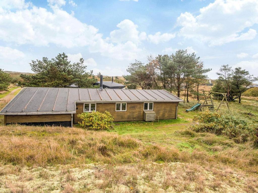a house with a metal roof in a field at Seaside Escape in Sonderho - By Traum Ferienwohnungen in Fanø