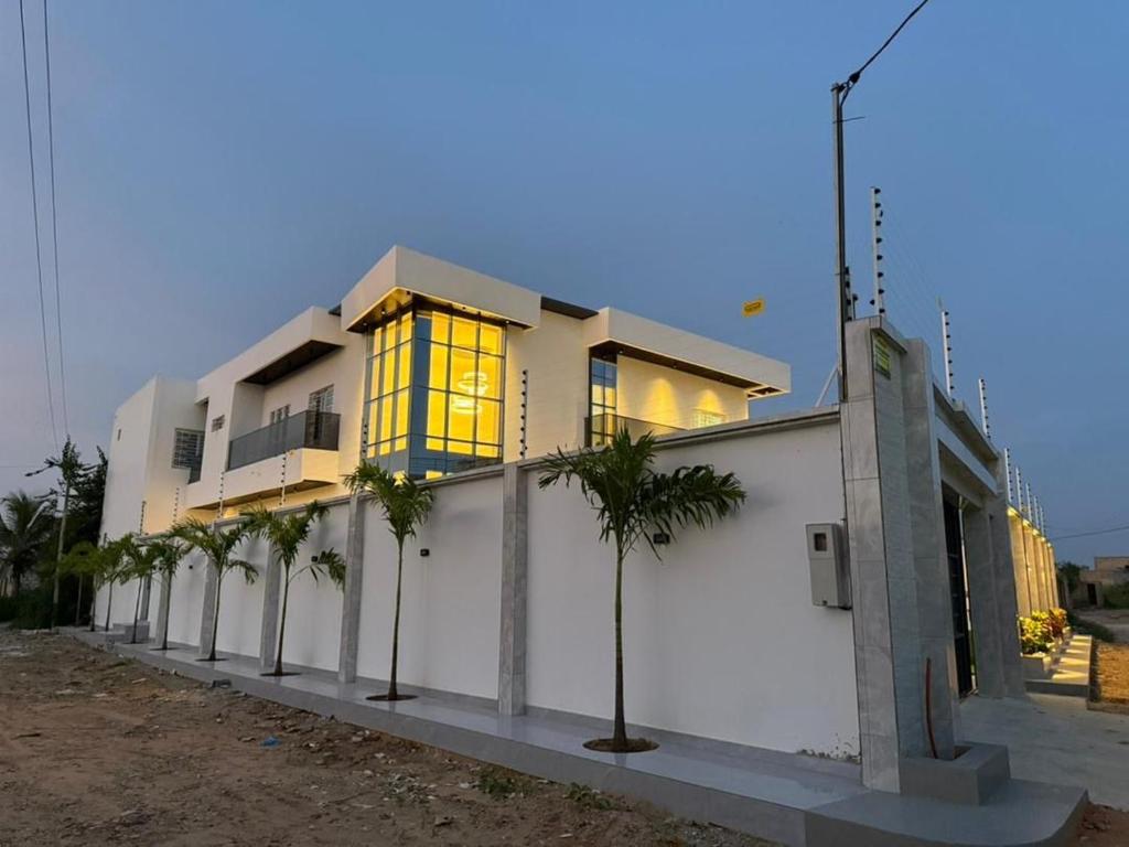 a building with palm trees in front of it at Modern and luxurious villa, comfort and tranquility in Saly Portudal
