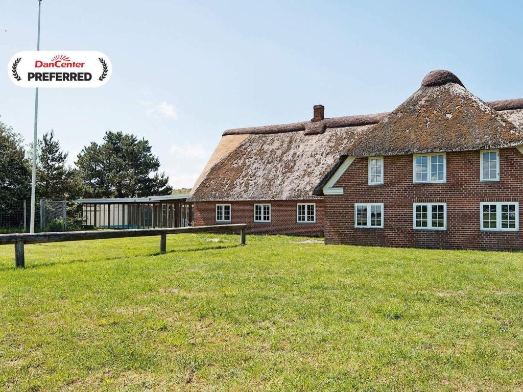 an old brick building with a thatched roof at 25 person holiday home in Rømø-By Traum in Mølby