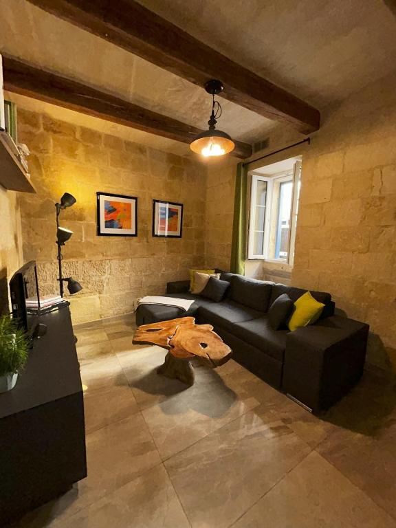 a living room with a couch and a table at De Rohan Central Townhouse 38 in Taʼ l-Infetti