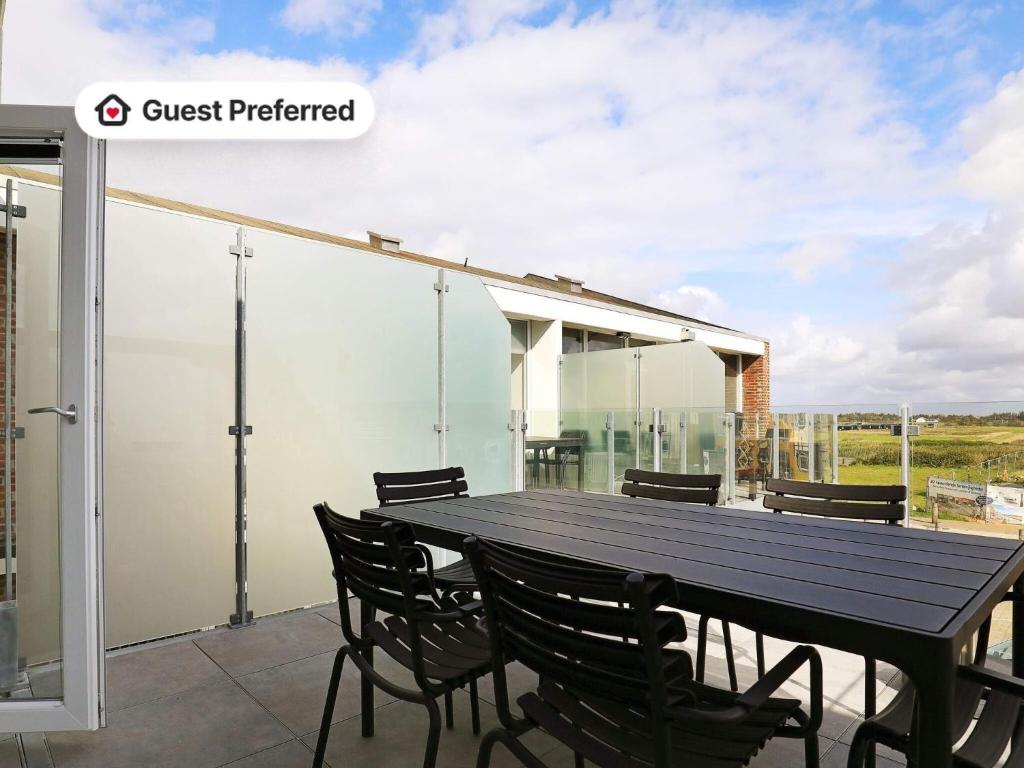 a patio with a black table and chairs at 8 person holiday home in Ringkøbing-By Traum in Ringkøbing