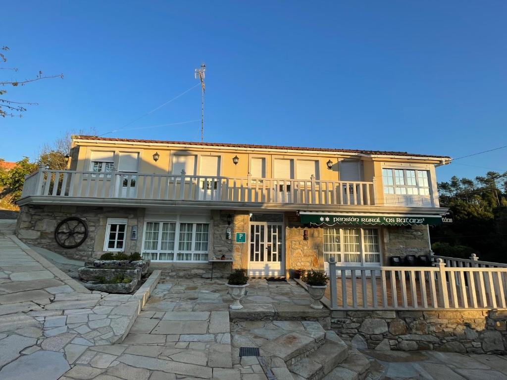 een groot geel huis met een balkon bij Casa Os Batáns in Vimianzo