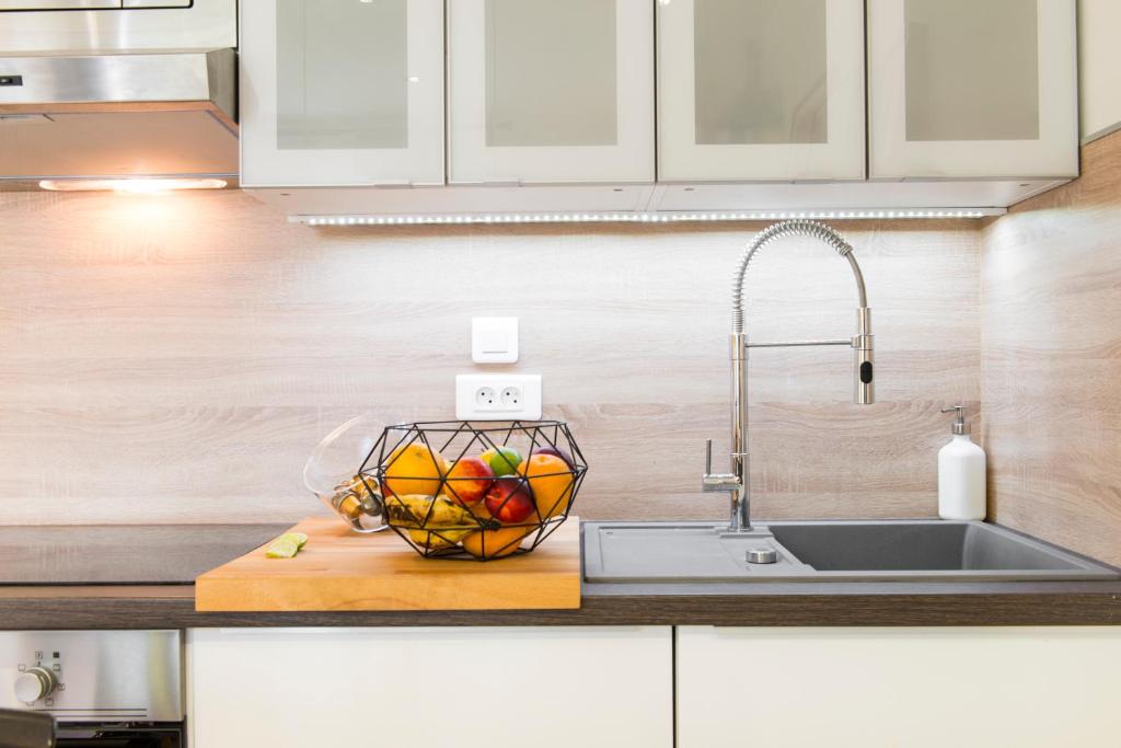 a kitchen counter with a sink and a bowl of fruit at Unsejouranantes - Le Magellan in Nantes