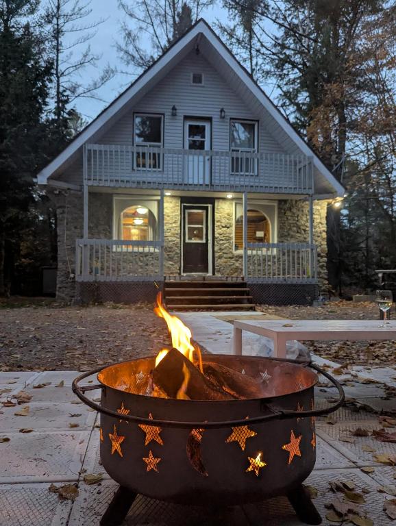 a fire pit in front of a house at Chalet Lumière in Rawdon