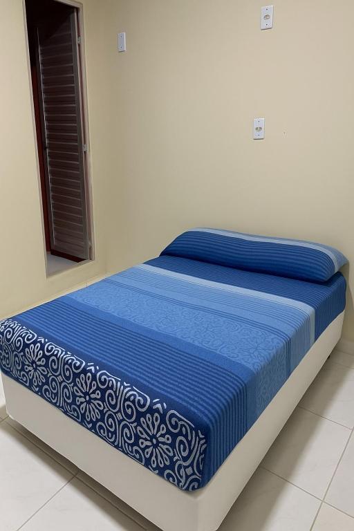 a bed in a room with a blue and white mattress at Acomodação no centro da COP 30 in Belém