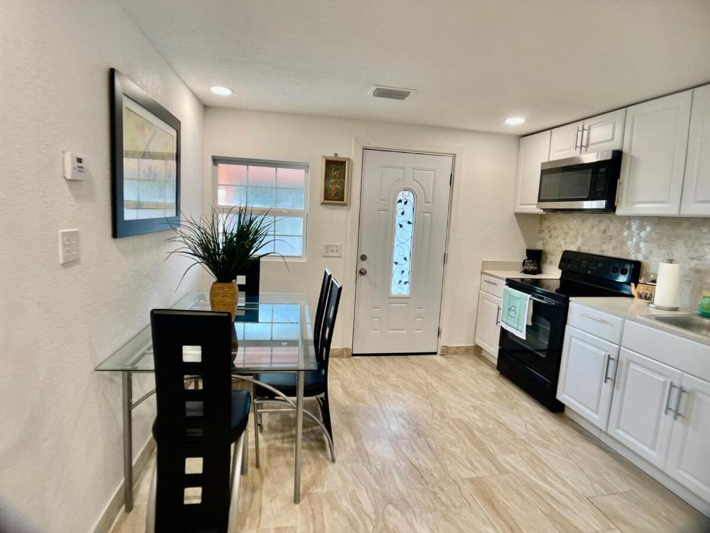 cocina con mesa de cristal y comedor en Loving Apartment! 5 min from the beach in car, en Clearwater