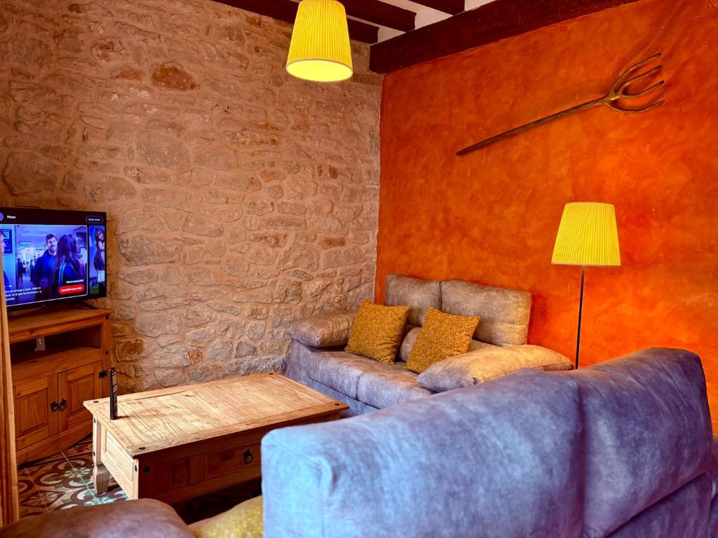 een woonkamer met een bank en een tv bij Casa rural Valdecid in Valdeande