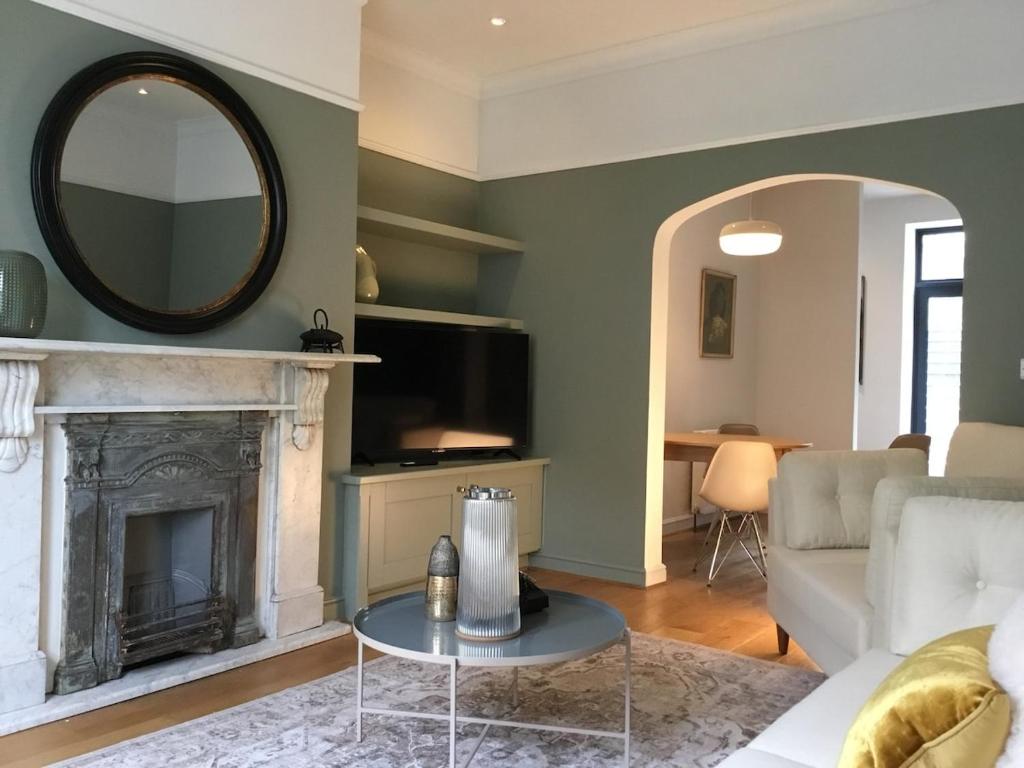 een woonkamer met een open haard en een spiegel bij Beautiful 3 bed house in central Hebden Bridge in Hebden Bridge