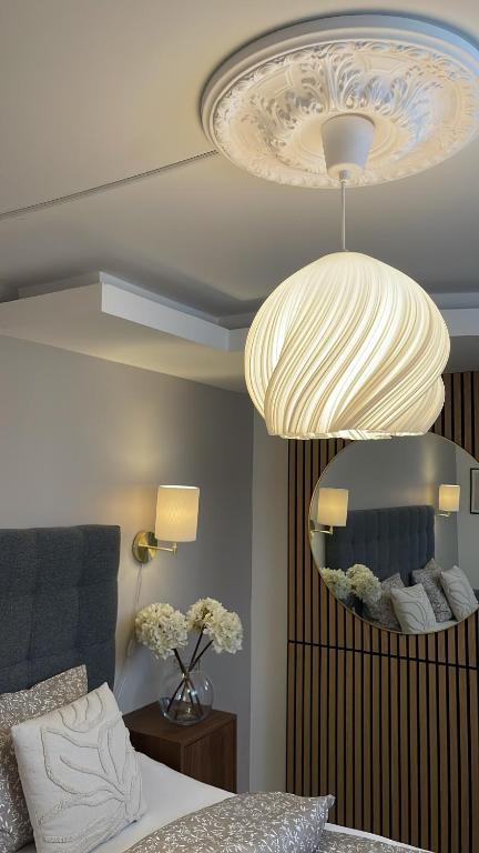 a bedroom with a bed and a large chandelier at Strömspärlan - Nordic Stay Strömstad in Strömstad