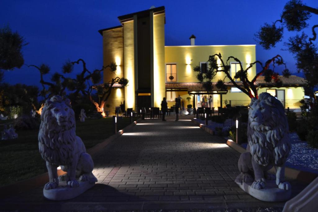 two statues of birds in front of a building at night at Villa D'Anzi B&B in Ginosa