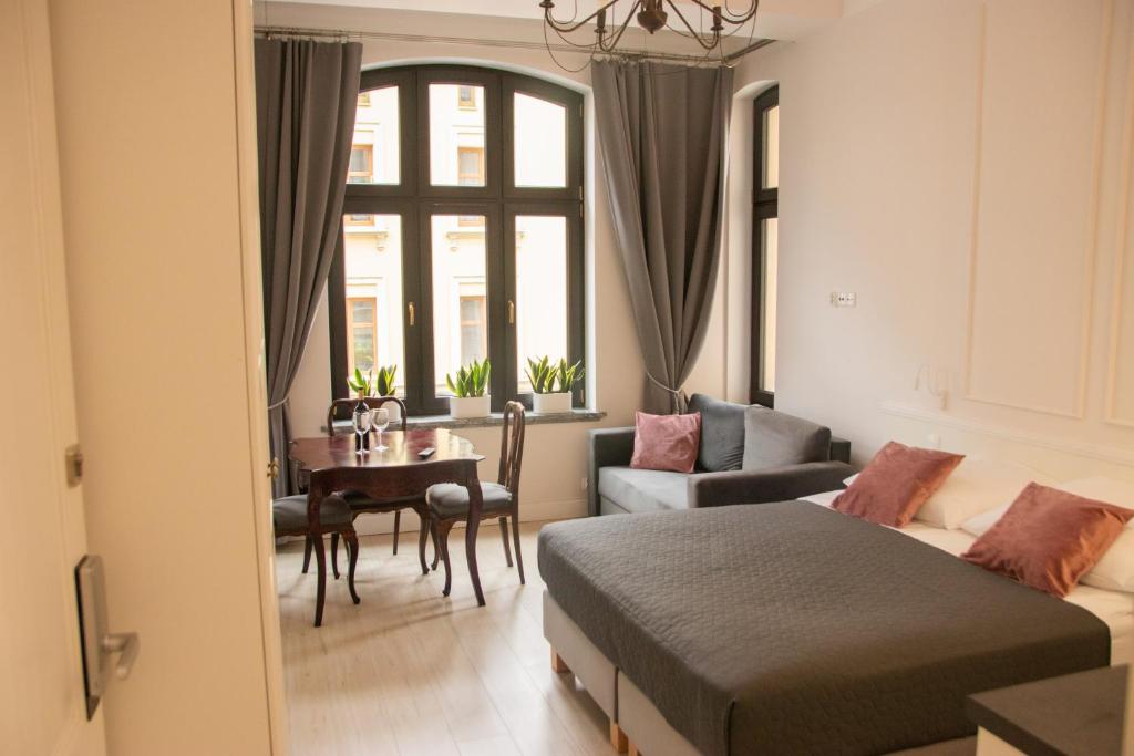 a bedroom with a bed and a dining room at Apartamenty PREMIUM Rynek 21 in Toruń
