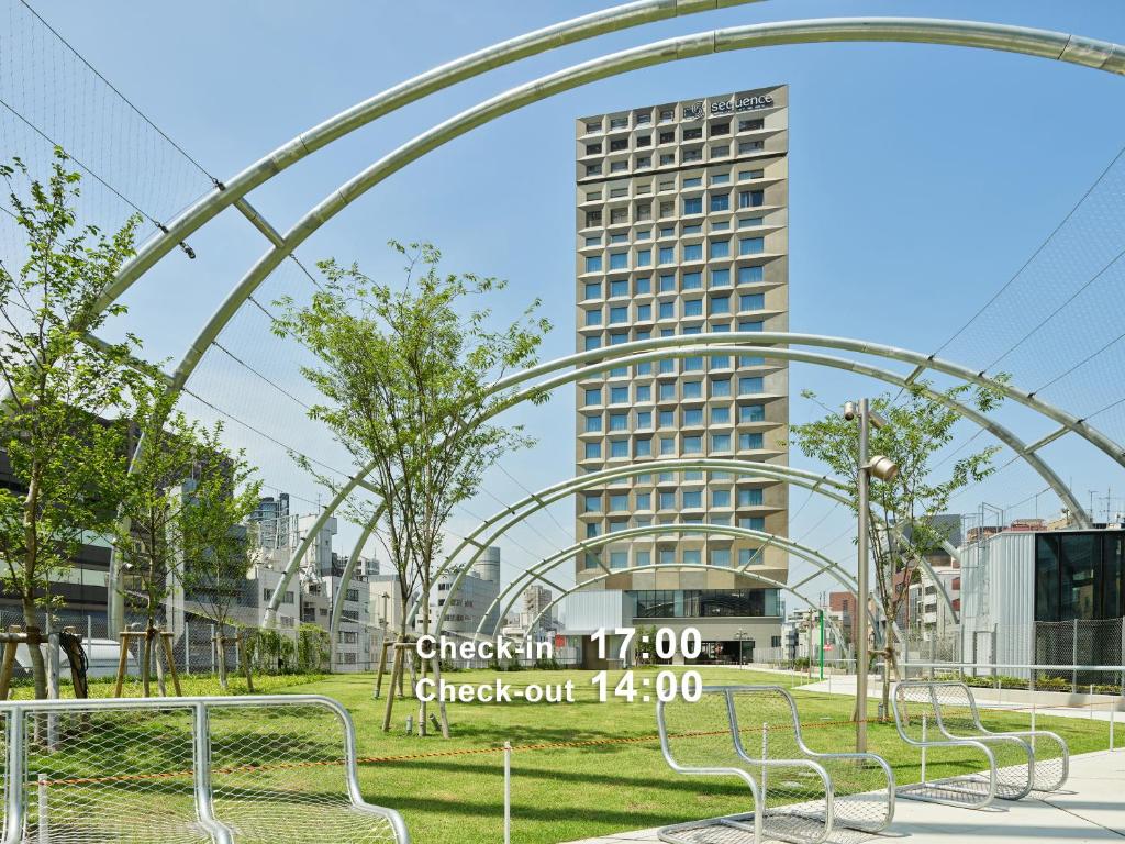 a group of benches in a park with a tall building at sequence MIYASHITA PARK - Shibuya in Tokyo