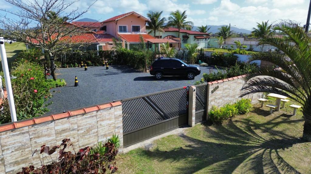 a car parked in a parking lot with a fence at Pousada Mar e Luz in Ilha Comprida
