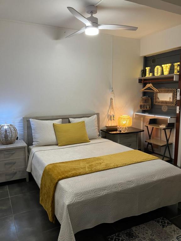a bedroom with a bed with a yellow blanket on it at Tilys lodge in Capesterre-Belle-Eau