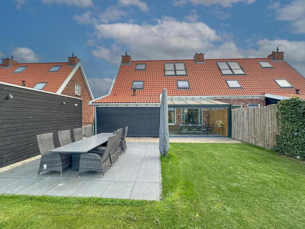 a backyard with a picnic table and a house at Happy Beach 48 in Colijnsplaat