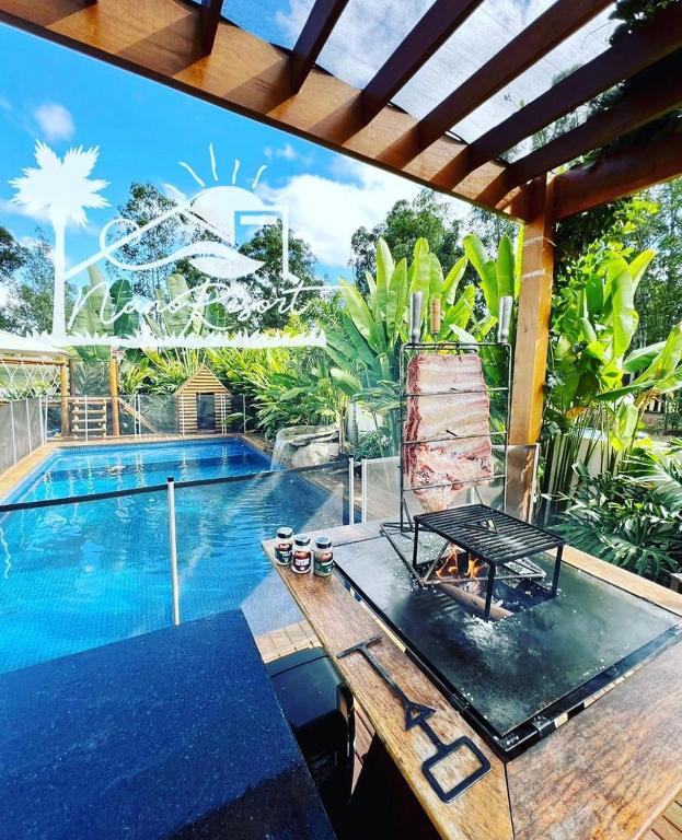 a pool with a table next to a swimming pool at Nano Resort in Porangaba