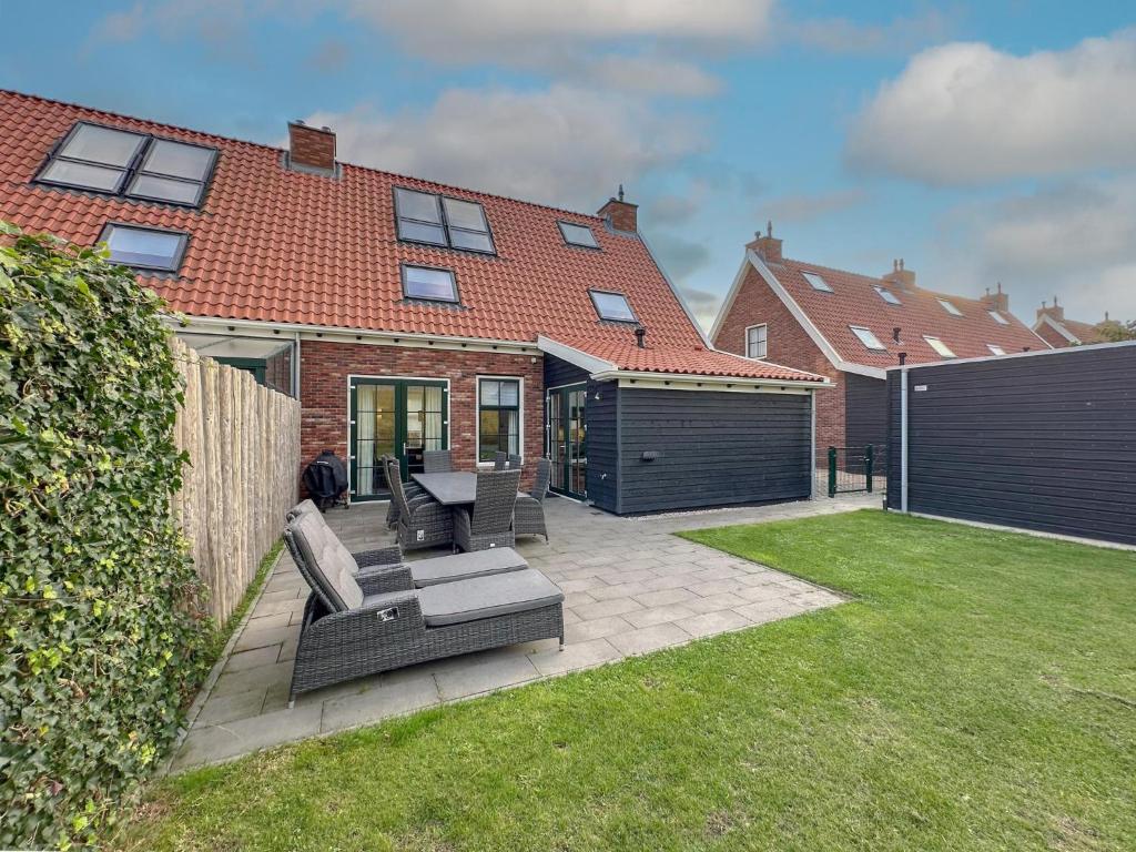 a backyard of a house with a couch and a fence at Happy Beach 50 in Colijnsplaat