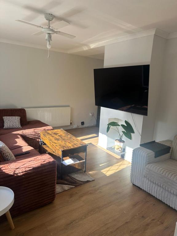 Una sala de estar con dos sofás y un televisor de pantalla plana. en Newport by M4, en Newport