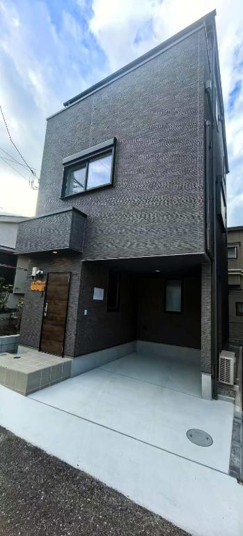a building with a window on the side of it at 新築江の電腰越駅前徒歩1分鎌倉江の島観光に最適鎌倉腰越駅前ｂ棟 in Kamakura